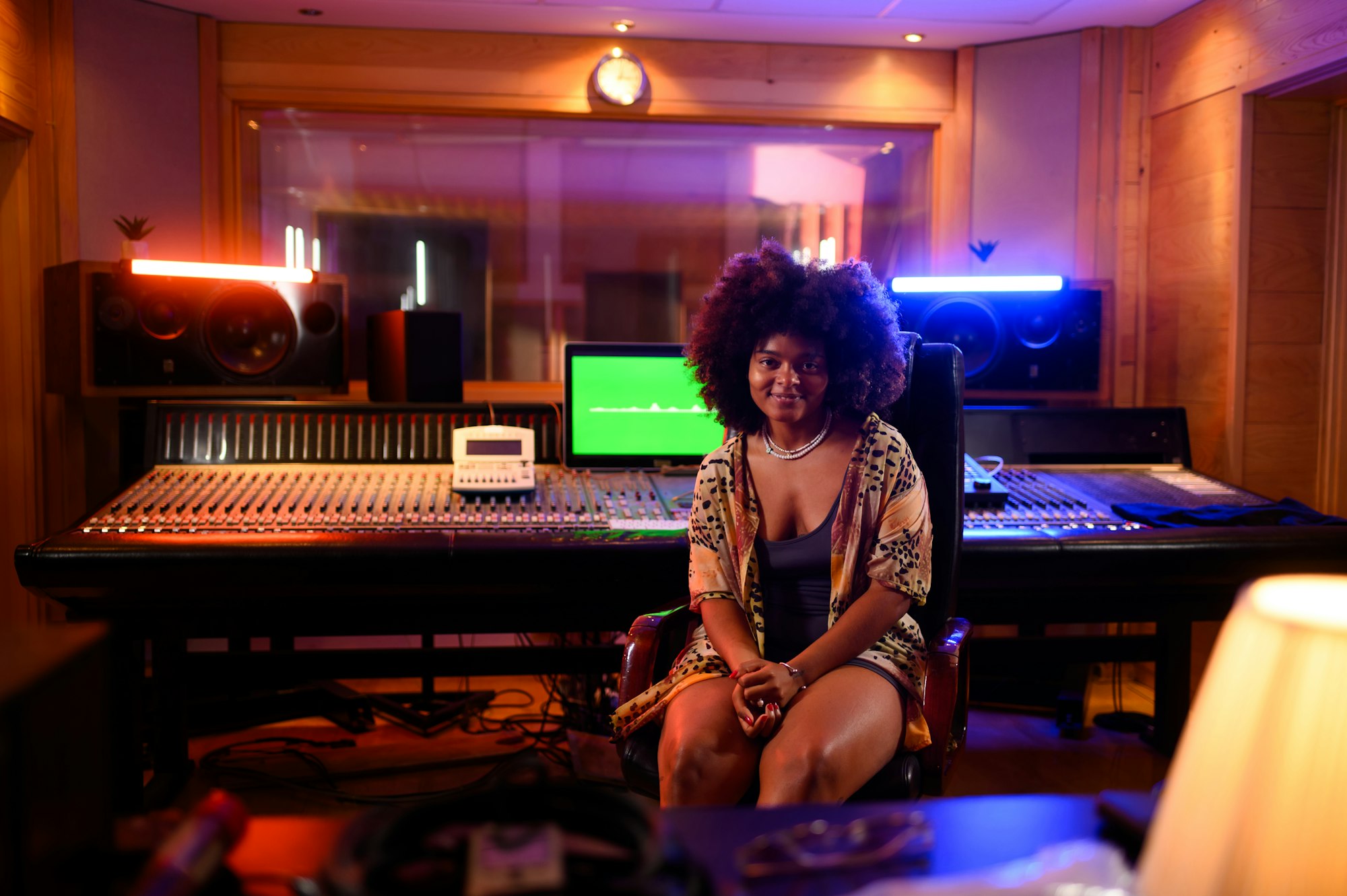 Hispanic woman music producer and sound engineer sitting at the soundboard